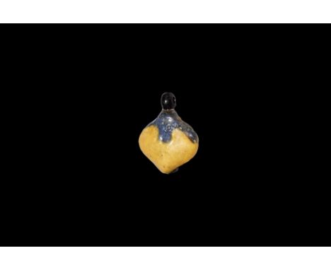 Amarna Period, 1353-1336 BC. A glazed composition amuletic pendant of a mandrake fruit with loop above and another to the rev