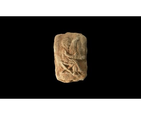 20th-17th century BC. A rectangular baked clay plaque with low relief motif of a seated musician in long robe playing a harp.