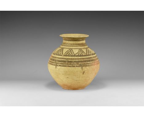 2nd millennium BC. A biconvex ceramic jar with flat base, waisted neck, everted rim; concentric painted bands to neck and sho
