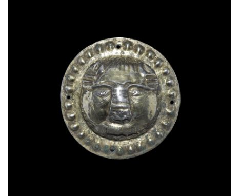 3rd-6th century AD. A silver-gilt discoid plaque with border of raised domes, central feline mask with fluted border, rectang