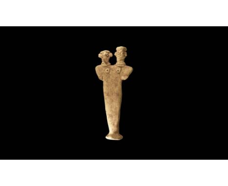 1st millennium BC. A flat-backed ceramic figurine depicting a female with two heads; the eyes and breasts formed with round r