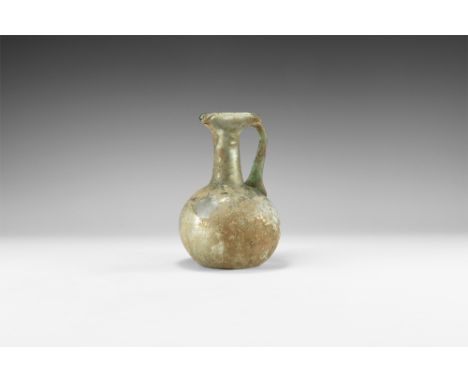 3rd-4th century AD. A large globular iridescent glass body with dimple base, tapering neck with folded trefoil rim, flat-sect