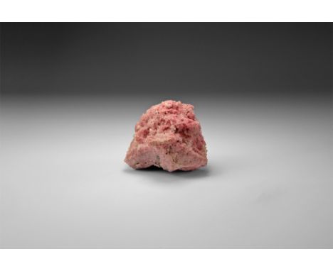 A fine specimen consisting of numerous rosettes of pink rhodochrosite speinkled with tiny quartz and pyrite crystals, in whit