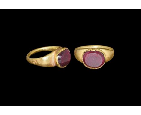 4th-5th century AD. A hollow-formed lentoid-section hoop with expanding shoulders, flared cell and inset garnet cabochon with