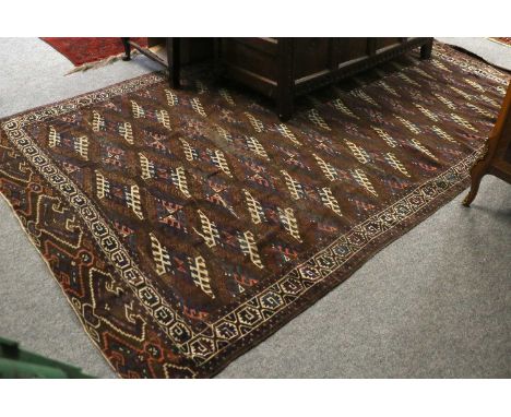 Yomut Carpet, the chocolate brown field with columns of Dyrnak Güls enclosed by ivory borders meandering vines, 320cm by 189c