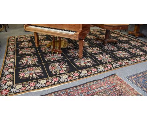 Needlepoint Carpet, the compartmentalised field of floral sprays enclosed by meandering vine borders, 473cm by 327cm