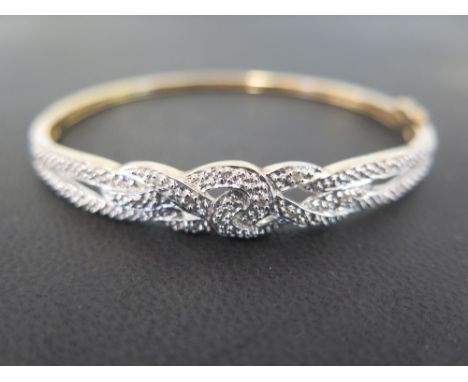 A 9ct gold diamond hinged bangle - Of bi-colour twist design - Hallmarked Sheffield - Inner diameter 6.3cms - Weight approx 1