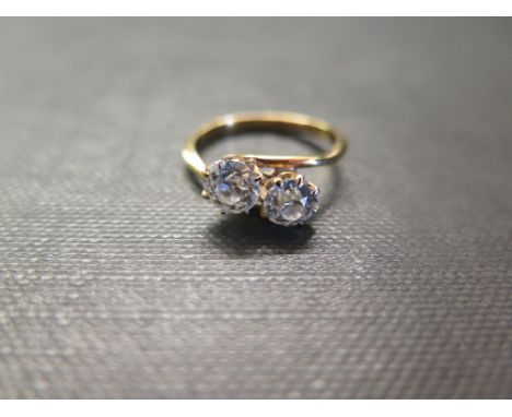 A diamond two-stone crossover ring - The old-cut diamonds to the asymmetric shoulders and plain band - Estimated total diamon