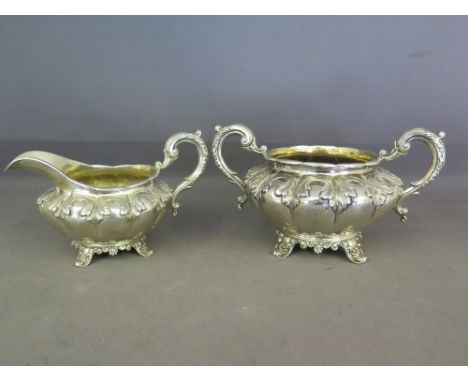 A good William IV silver lobed sugar bowl with matching cream jug by Reilly and Storer - decorated with a frieze of foliate d