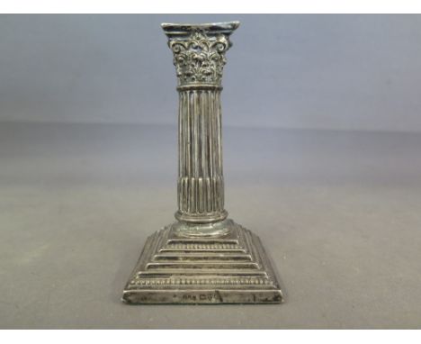 A silver hallmarked candlestick in Corinthian column design, hallmark for 1904-5 Chester, E J Trevitt and Sons - Height 12 cm