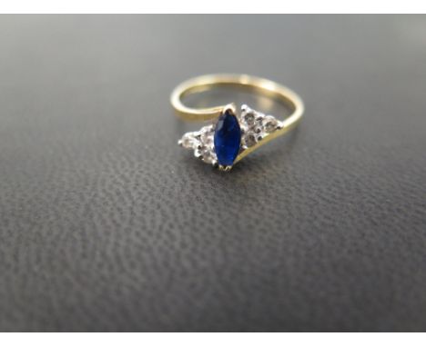 An 18ct gold sapphire and diamond dress ring - The marquise-shape sapphire to the brilliant-cut diamond trefoil shoulders, as