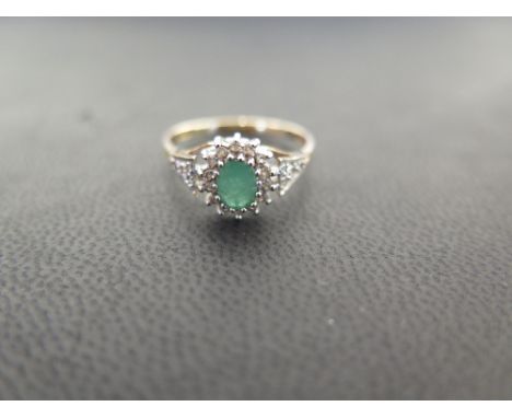 A 9ct gold emerald and diamond cluster ring - With single-cut diamond shoulders - Hallmarked London - Ring size P - Weight ap