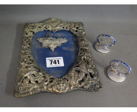 A silver embossed photo frame - missing easel back - 19 cm x 14 cm - two silver enamel menu stands - missing some enamel and 