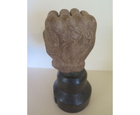 A reconstituted stone fist on a wooden stand - Height 23 cm x Width 10 cm 
Condition report: Tool marks to fist split to stan