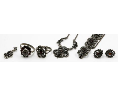 Sechsteilige Granatgarnitur. Silber, verschiedene Feingehalte. Bestehend aus: Damenarmband, zwei Damenringen, Collier, Ketten