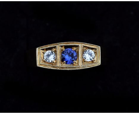 A 14 karat gold ring, set in the middle with a synthetic blue sapphire approx. 0.18ct. and two synthetic white spinels each a