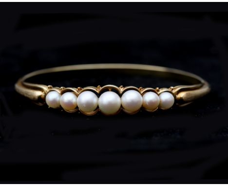 A 14 karat gold bangle with Akoya pearls. The pearls are set on top of the bracelet and the gold is partly satinated. Gross w