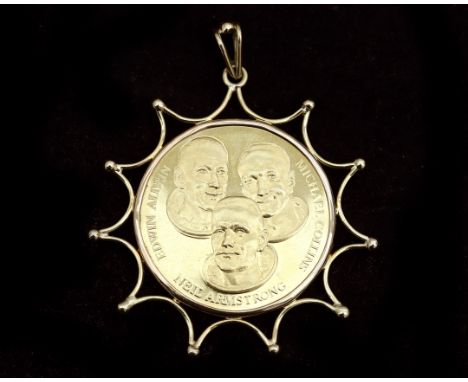 A 14 karat gold pendant, in the shape of a wire bent sunbeams in the center set with a commemorative medal, a (gold) commemor