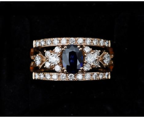 An 18 karat rose gold harp ring, centrally set with an oval cut sapphire (treated) approx. 0.60ct. surrounded by thirty-four 