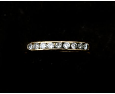 An 18 karat gold half alliance ring set with nine brilliant cut diamonds in rail setting, approx. 0.14 ct in total. approx. C