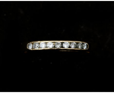 An 18 karat gold half alliance ring set with nine brilliant cut diamonds in rail setting, approx. 0.14 ct in total. approx. C