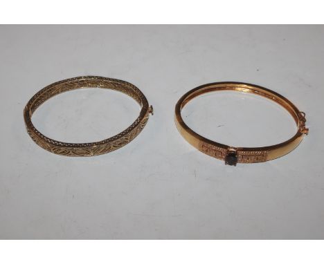 A 9ct gold filigree work snap bangle, approx. total weight 12gms and a yellow metal and stone set snap bangle, approx. 16gms