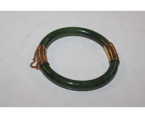 A jade and yellow metal mounted snap bangle, approx. total weight 40gms