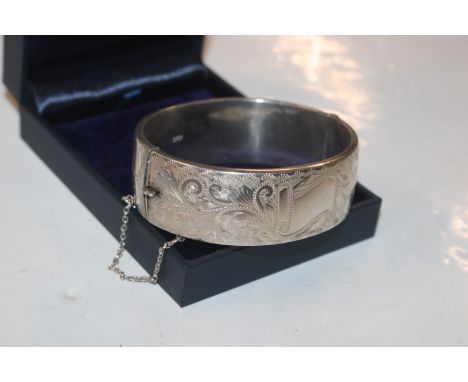 A 1962 Birmingham silver T. H. Ltd bangle with vacant cartouche, approx. 34gms