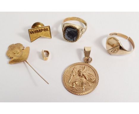 A 9 carat gold St Christopher 3.9g, two 9 carat gold signet rings 6g, a 14 carat gold tie pin 2.2g and a yellow metal Indian 