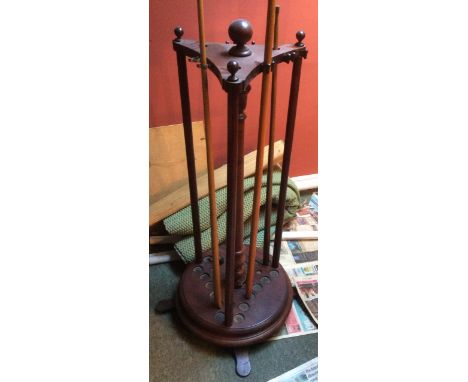 Circular mahogany nineteen-cue snooker cue stand with globe finials.