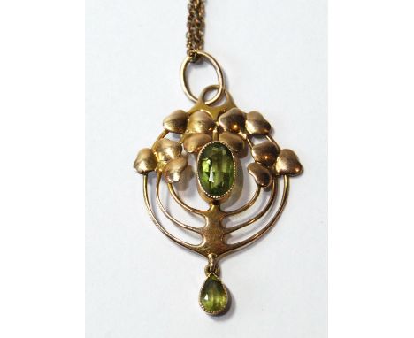 Edwardian gold pendant in the manner of Charles Rennie Mackintosh with loops and leafage about an oval peridot by Murrle Benn