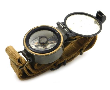 A British Army wrist compass, reference number 6B/2593, serial number 130688/58, with broad arrow mark, on canvas webbing str