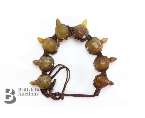 A vintage Chinese carved jade bracelet, woven and set with eight graduated jade carved turtles, ranging from 20mm to 25mm.&nb