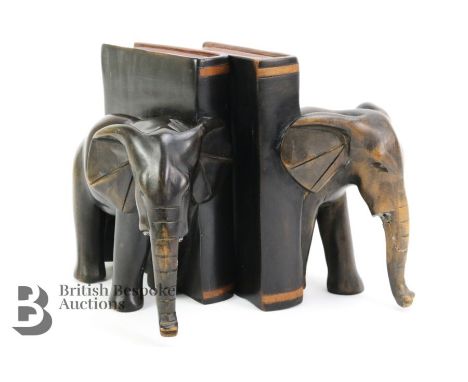 Pair of ebony elephant book ends, tusks missing. Measures approx. 16 x 18 cms each. (af)Condition ReportTrunk to one is damag