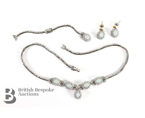 A silver metal opal and diamante necklace, bracelet and earring suite.
