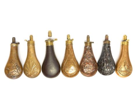 Six embossed copper and brass powder flasks, and one other flask  by Hawksley with incorrect fitting spout. 
