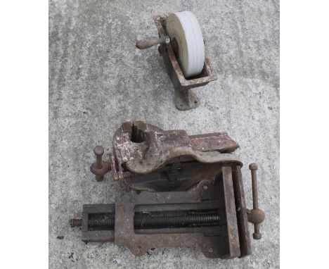 Two vintage bench vices and a sharpening stone wheel. 
