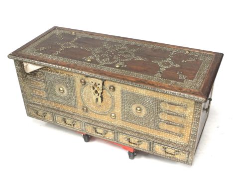 A contemporary Indian brass bound and studded trunk. On turned supports with five drawers along the bottom and candle box ins
