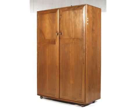 A mid-century Ercol oak wardrobe (blue &amp; gold label). With two doors and on castors. L121cm x D54cm x H182cm Condition Re