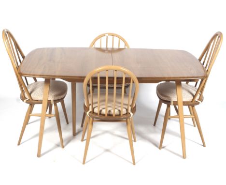 A mid-century light oak Ercol rectangular extending dining table and four chairs. With two leaves, on square tapering support