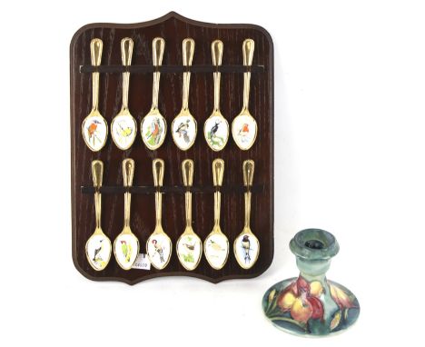 A Moorcroft candlestick and spoon collection. The candlestick in the 'Freesia' pattern on a turquoise ground, H8.5cm, the gol