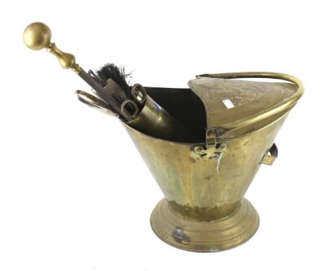A brass fire side companion set. Including a coal scuttle and tools in a shell case.  