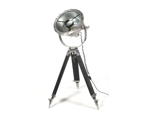 A substantial spot light on a tripod base. In a cast metal housing with wood and metal surveyors' type adjustable tripod. Dia