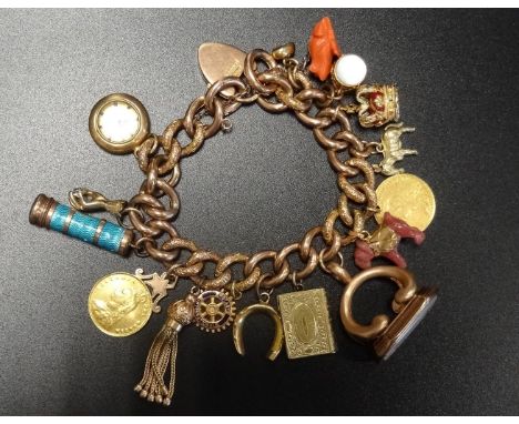 NINE CARAT GOLD CURB LINK CHARM BRACELETwith a good selection of gold and other charms, including an 1887 Victorian shield ba