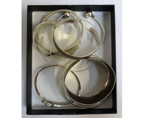 EIGHT SILVER BANGLESincluding one with pierced crystal set tree decoration, another with ball finials, an entwined triple ban