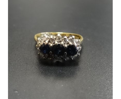 SAPPHIRE AND DIAMOND CLUSTER DRESS RINGthe three central sapphires in multi diamond surround, on eighteen carat gold shank, r