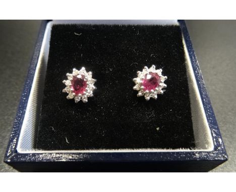 PAIR OF RUBY AND DIAMOND CLUSTER EARRINGSthe central ruby on each in twelve diamond surround, in nine carat gold 