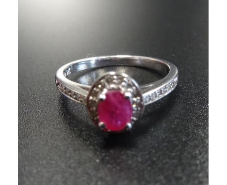 RUBY AND DIAMOND CLUSTER RINGthe central ruby in diamond surround and with further diamonds to the shoulders, in nine carat w