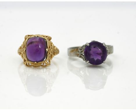 TWO CABOCHON AMETHYST SINGLE STONE RINGS (2)Comprising; a gold ring mounted with a cushion shaped cabochon amethyst, between 