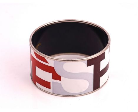 A HERMES PARIS ENAMELED BANGLEThe wide bangle spelling Hermes in variously coloured capital letters, detailed made in Austria